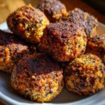 A close-up shot of a pile of golden-brown, crispy Easy Black Bean Meatballs on a white plate.