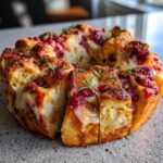 Close-up of Festive Cranberry Brie Pull-Apart Bread, showing gooey cheese and tart cranberries baked into golden bread.