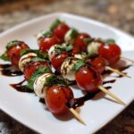 Close-up of Mini Caprese Skewers with Balsamic Glaze, featuring cherry tomatoes, mozzarella balls, and basil.