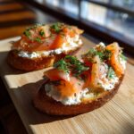 Two Smoked Salmon Crostini topped with cream cheese and fresh dill, ready to be served.