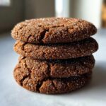 A close-up stack of four delicious Soft Ginger Molasses Cookies, coated in sparkling sugar.