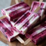 Close-up of frozen Berry Yogurt Pupsicles on a wooden board, perfect for dogs.