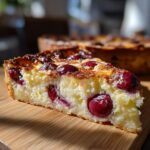 Close-up of a slice of Cherry Almond Clafoutis, showcasing fresh cherries and almond topping.