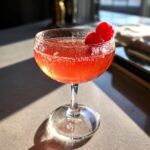 A vibrant Cherry Blossom Cocktail in a coupe glass, garnished with cherries, perfect for spring.