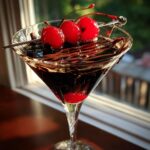 A delicious Chocolate Covered Cherry Martini garnished with fresh cherries and chocolate drizzle.