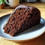 A slice of rich, moist Chocolate Fudge Cake on a plate, ready to be enjoyed.