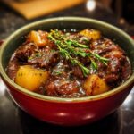 Close-up of a bowl of Classic Beef Stew, with tender beef, potatoes, and herbs.