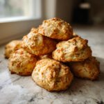 A stack of freshly baked Coconut & Pumpkin Dog Biscuits on a marble surface.