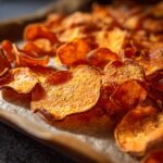 Close-up of a tray of freshly baked crunchy sweet potato chips.