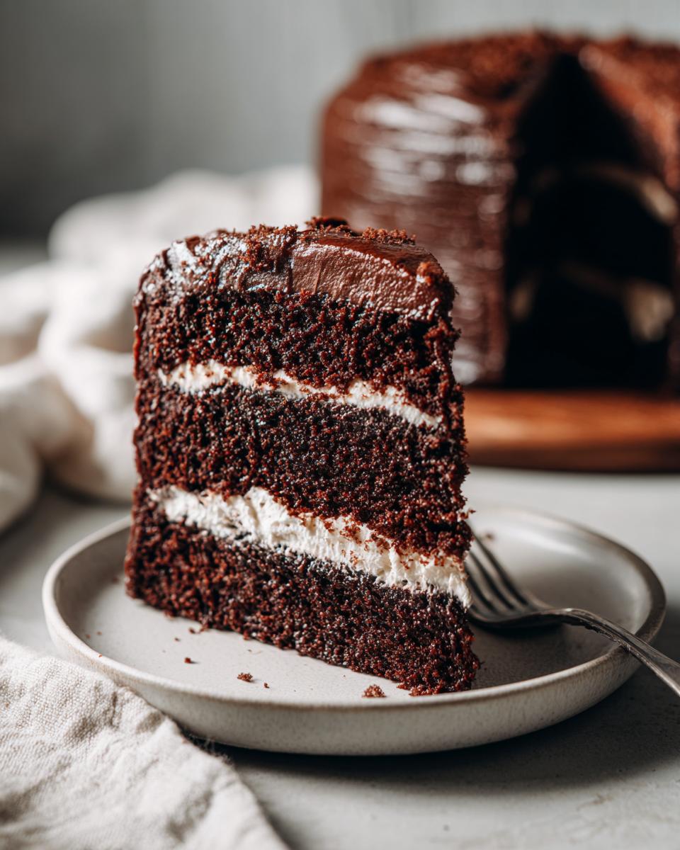A slice of Guinness Chocolate Cake on a plate, showing layers of cake and frosting.
