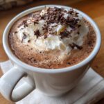 A mug of hot chocolate with whipped cream and chocolate shavings, perfect for a cozy treat. Featuring the primary keyword: Hot Chocolate with a Secret Upgrade.