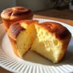 Close-up of a Japanese Cotton Cheesecake Cupcake cut open, showing its soft, fluffy texture.