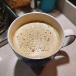 A close-up of a steaming London Fog (Earl Grey Latte) in a white mug, showing the foamy top.