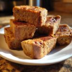 Close-up of a stack of homemade Peanut Butter & Banana Bones on a white plate.