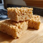 Close-up of stacked Peanut Butter Rice Krispie Treats on a wooden board.