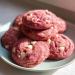 Pile of delicious Pink Velvet Cookies with white chocolate chips on a blue plate. The perfect Pink Velvet Cookie recipe.