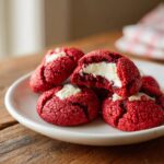 Close-up of Red Velvet Thumbprint Cookies with cream cheese filling on a white plate.
