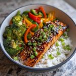 A vibrant Teriyaki Salmon Bowl with Veggies, featuring salmon, rice, broccoli, and bell peppers.