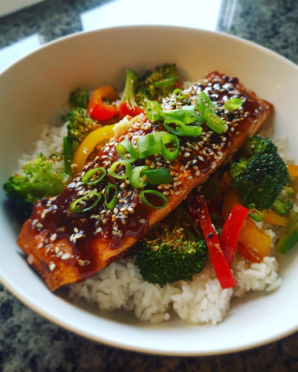 A vibrant Teriyaki Salmon Bowl with Veggies featuring salmon, rice, broccoli, and bell peppers.