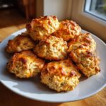 A plate piled high with freshly baked Tuna & Cheese Protein Bites, golden brown and delicious.