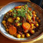 Close-up of a bowl of Vegan Chickpea Tagine with carrots, chickpeas, and herbs.