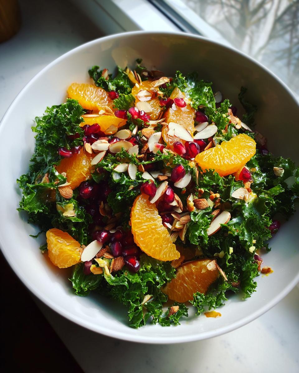A vibrant Winter Kale Salad with Citrus Vinaigrette, oranges, pomegranate seeds, and almonds.