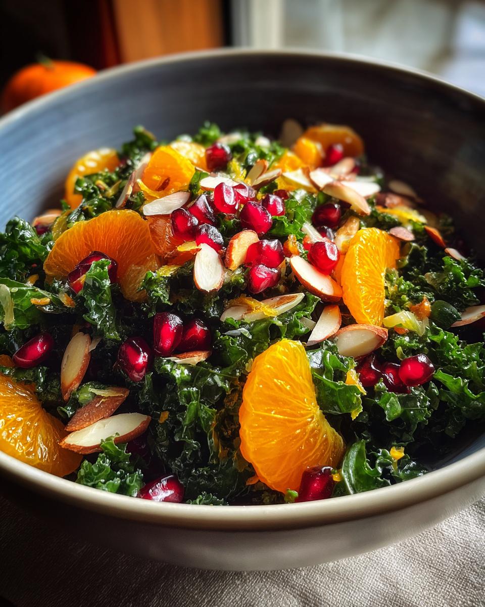 Close-up of a Winter Kale Salad with citrus segments, pomegranate seeds, and almonds.