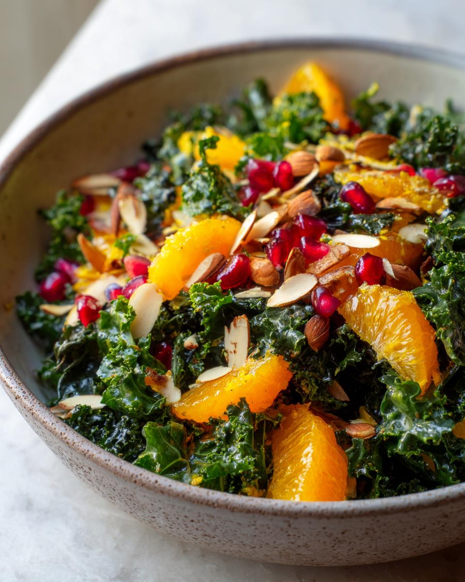 Close-up of a Winter Kale Salad with citrus segments, pomegranate seeds, and almonds.