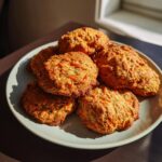 A plate piled high with homemade carrot and apple doggie cookies, a healthy treat for dogs.