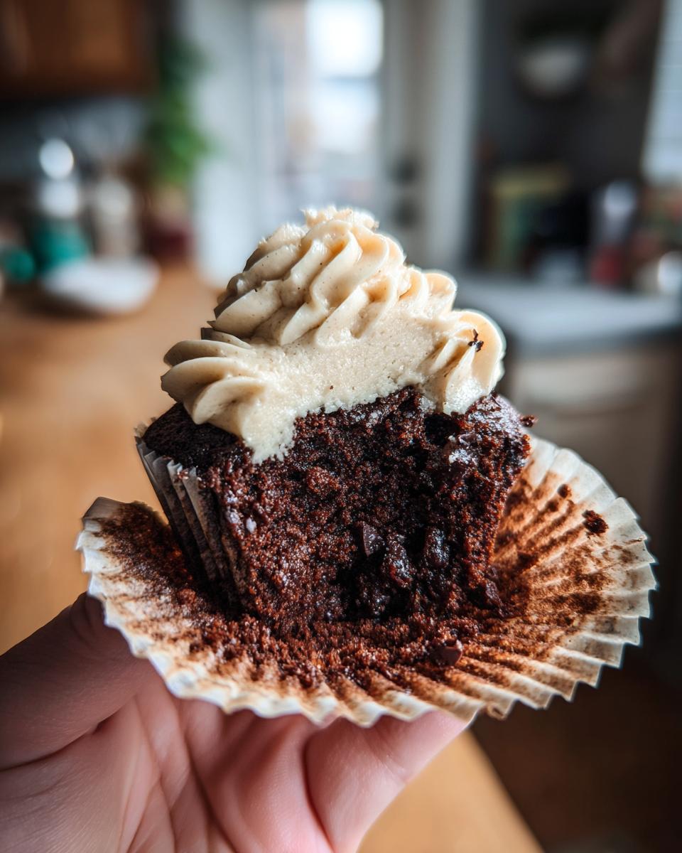 Close-up of a Chocolate Guinness Cupcake cut in half, showing the moist cake and frosting.