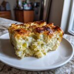 Close-up of a slice of Creamy Leek and Potato Pie on a white plate, showing the creamy filling.