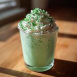 A delicious Minty Shamrock Shake Cocktail in a glass, topped with whipped cream and green sprinkles.