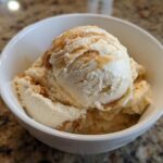 Close-up of a bowl of Peanut Butter Banana Frozen Yogurt Treats, drizzled with peanut butter.