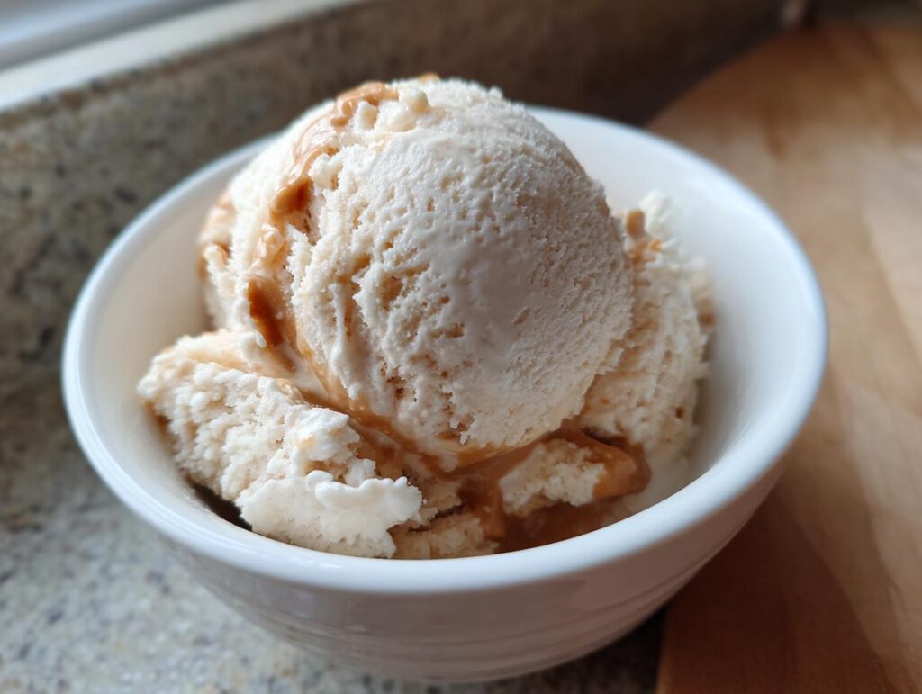 A bowl of Peanut Butter Banana Frozen Yogurt Treats, drizzled with peanut butter.