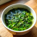 Close-up of a bowl of fresh Spinach and Herb Broth, a vibrant green, healthy soup.