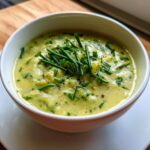 Close-up of a bowl of creamy Vegetarian Colcannon Soup, garnished with fresh chives and pepper.