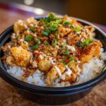 Close-up of a Buffalo Chicken Rice Bowl with chicken, rice, and toppings.