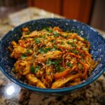 Close-up of a bowl of Easy Chicken Stir Fry with noodles, vegetables, and sesame seeds.