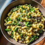 Delicious bowl of Goat Cheese Pasta with Spring Vegetables, including asparagus and peas.