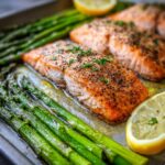 Close-up of Roasted Lemon Salmon & Asparagus on a sheet pan, ready to eat.