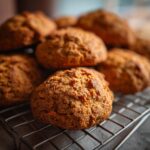 Close-up of freshly baked Apple Carrot Homemade Dog Cookie Coins on a cooling rack.