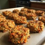 Close-up of freshly baked Apple Carrot Oat Dog Treats on a baking sheet.