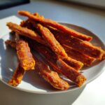 Close-up of a plate with homemade Beef and Pumpkin Chewy Dog Treat Sticks.