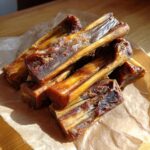 Pile of homemade Beef & Zucchini Baked Dog Chews on parchment paper, ready to be enjoyed.