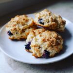 Close-up of three Blueberry Banana Dog Treat Biscuits on a white plate, perfect for your furry friend.