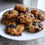 Pile of homemade Blueberry Oat Crunch Dog Cookies on a white plate, ready to be enjoyed.