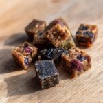 Close-up of Blueberry Oat Dog Training Bite Minis on a wooden surface, showing texture and ingredients.