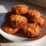 A stack of freshly baked Crunchy Homemade Peanut Butter Dog Biscuits on a white plate.