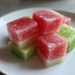 Close-up of colorful Cucumber Watermelon Frozen Dog Slush Cubes on a white plate.