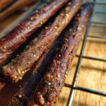 Close-up of several homemade beef dog chew sticks, showing texture and seasoning. These are the homemade beef dog chew sticks.